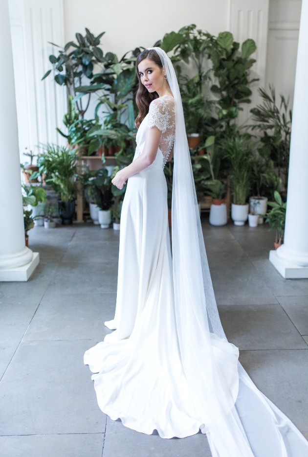 Bride in ivory wedding dress with lace top and veil.