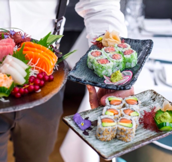 waiter serving sushi on molten plates