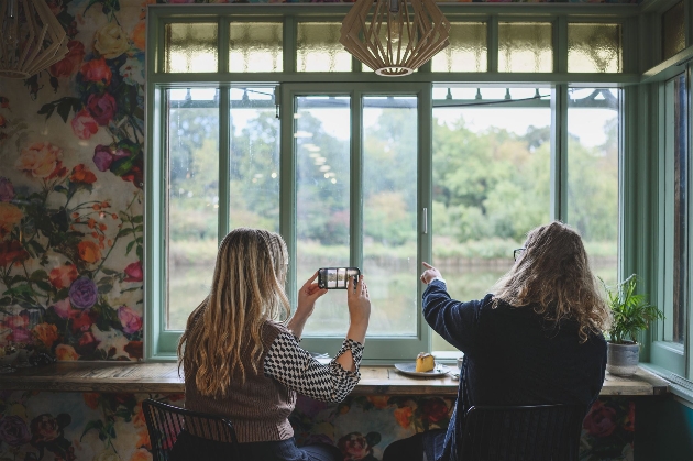 couple in side at window seat loking out at river