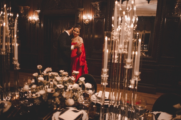 couple dancing in candle lit room with tables set for dinner
