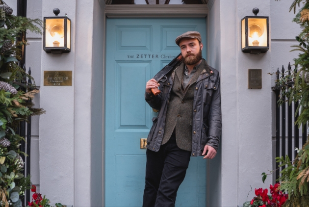 Man dressed in country attire standing outside building