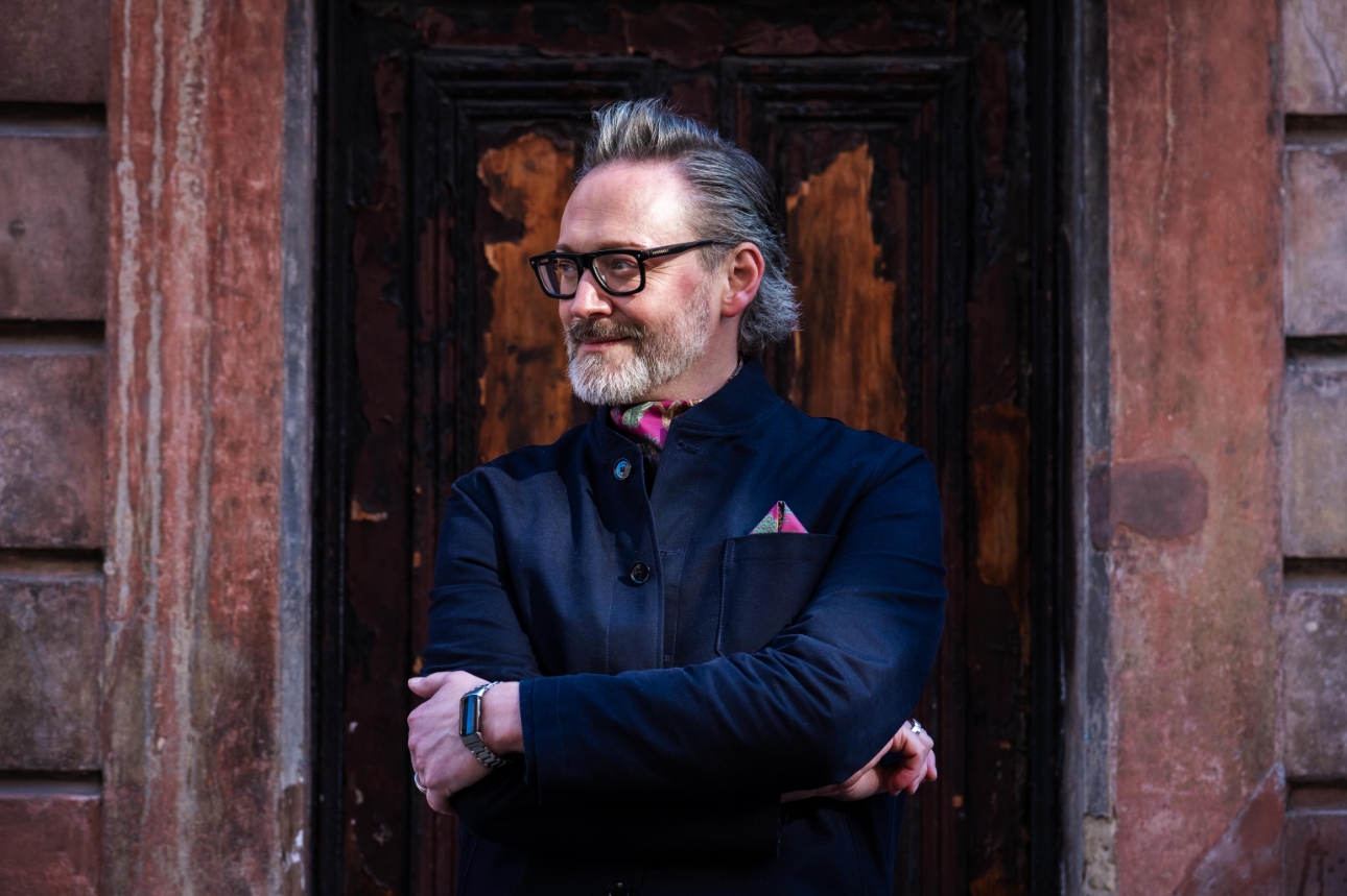 man in dark clothes with coloured accessories